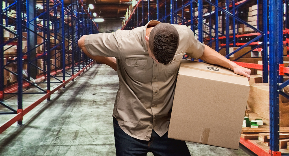 Worker with back pain holding cardboard box