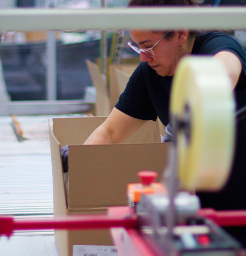 Employee setting up boxes on belt