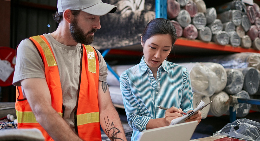Professional and warehouse worker discussing the job's physical demands