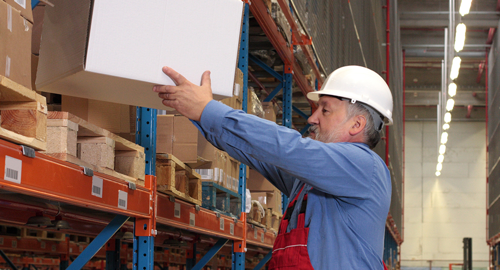 Warehouse employee placing a box on a shelf